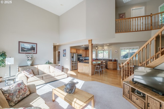 37676 Kathleen Ct, Lebanon, OR 97355 - living room featuring a high ceiling, stairway, ornate columns, and light wood-type flooring