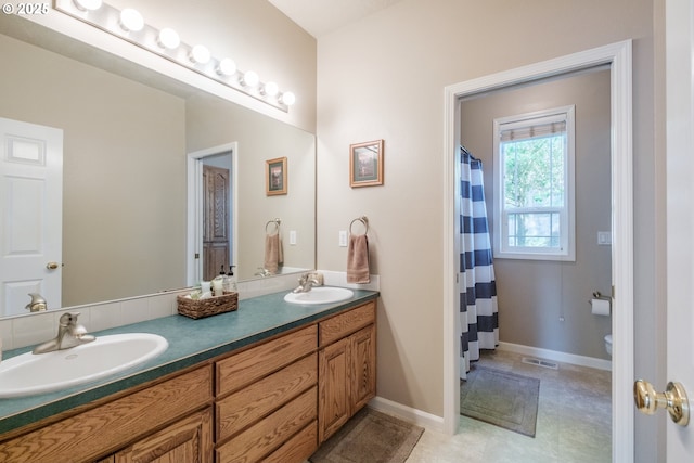 37676 Kathleen Ct, Lebanon, OR 97355 - bathroom featuring double vanity, toilet, baseboards, and curtained shower