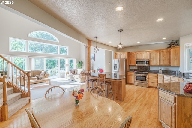 37676 Kathleen Ct, Lebanon, OR 97355 - dining area with a textured ceiling, light wood-type flooring, recessed lighting, and stairway