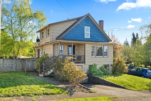 410 E D St, Rainier, OR 97048 - view of front facade featuring a chimney, covered porch, and stairway