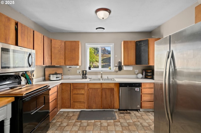 410 E D St, Rainier, OR 97048 - kitchen with appliances with stainless steel finishes, a sink, light countertops, and brown cabinetry