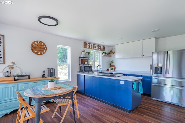 42810 NE 244th Ave, Amboy, WA 98601 - kitchen featuring stainless steel fridge, blue cabinets, a peninsula, dark wood-type flooring, and white cabinets