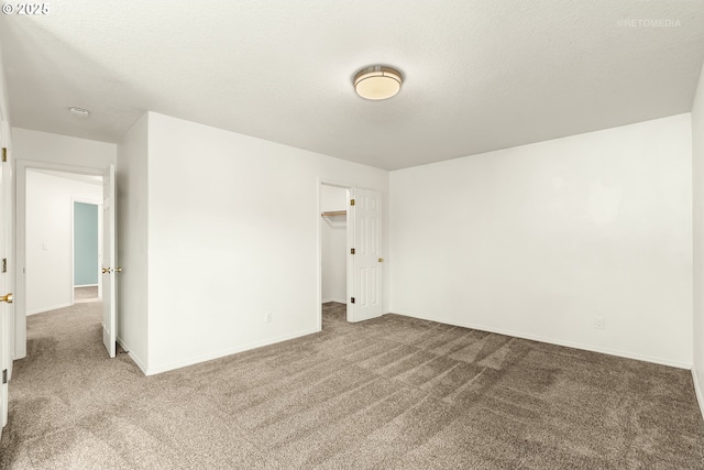 unfurnished room featuring carpet floors, a textured ceiling, and baseboards
