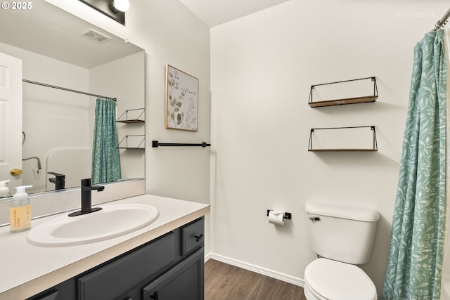 bathroom featuring visible vents, vanity, wood finished floors, toilet, and baseboards