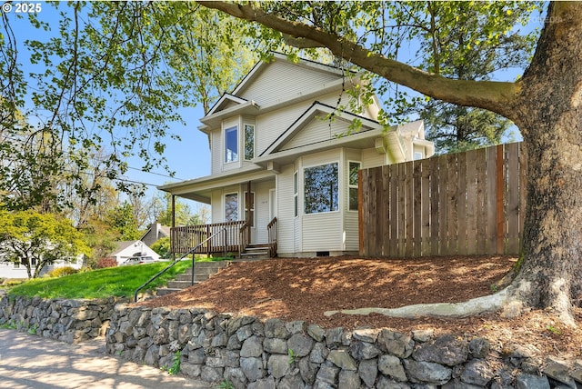 traditional-style house with a porch, crawl space, and fence