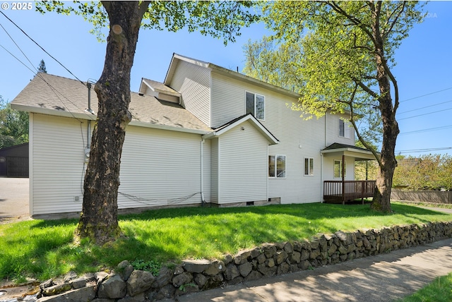 back of property featuring a lawn and fence