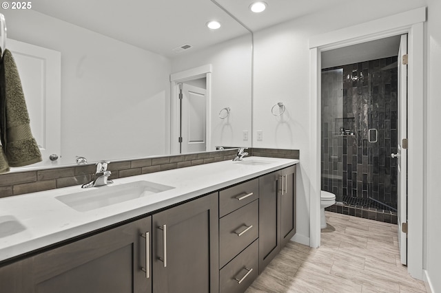 bathroom with vanity, a shower with shower door, and toilet