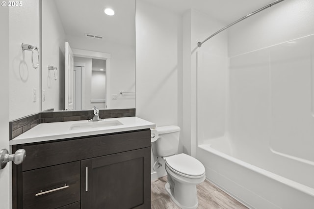 full bathroom featuring bathtub / shower combination, vanity, and toilet