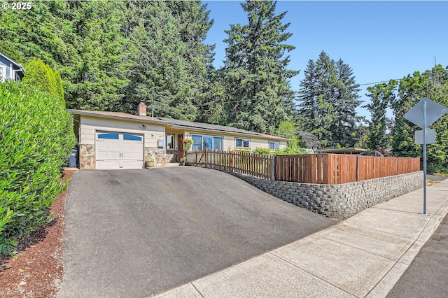 190 SE Shafford St, Estacada, OR 97023 - ranch-style home featuring a garage, asphalt driveway, a fenced front yard, and a chimney