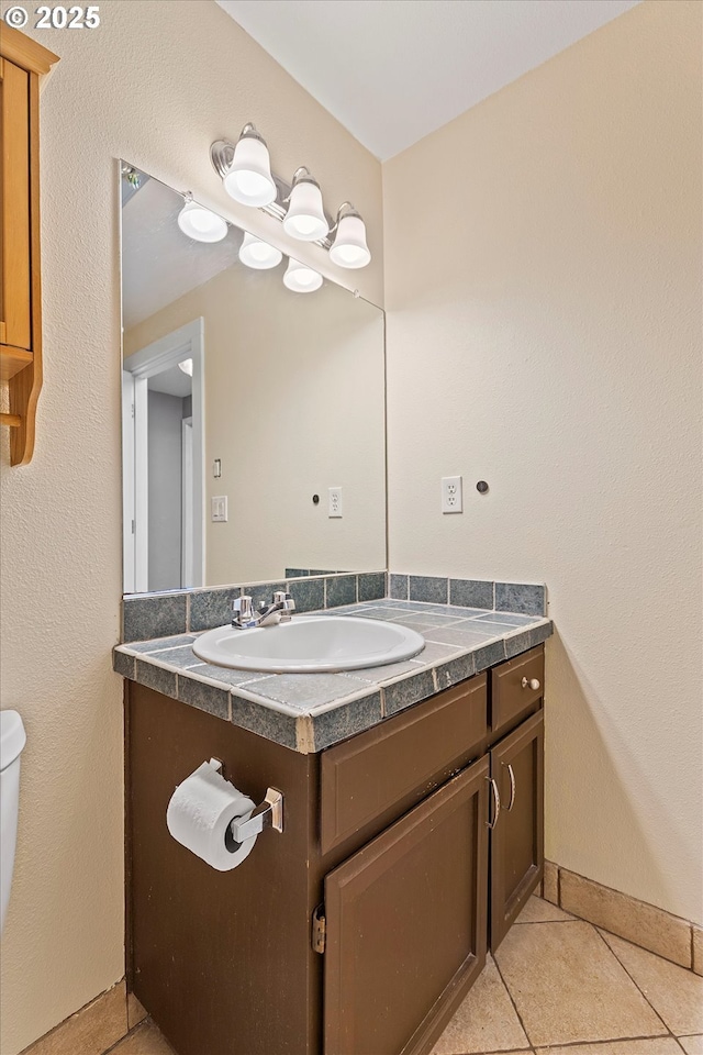 bathroom with vanity, tile patterned flooring, and toilet