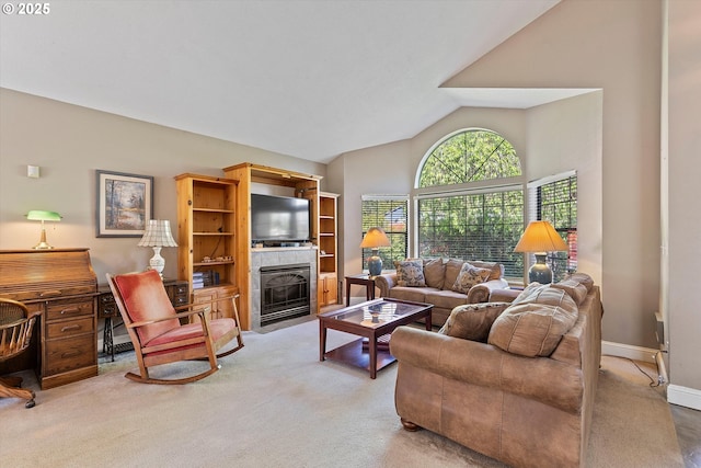 living area with light colored carpet, a fireplace, lofted ceiling, and baseboards