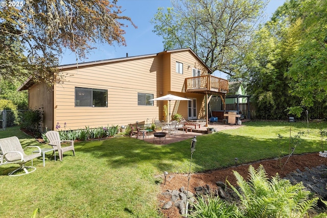 rear view of property featuring a patio area, a hot tub, and a balcony