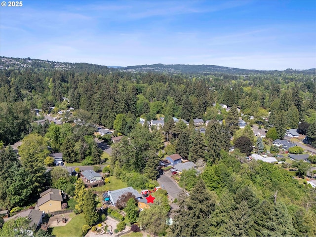 view of property location with a forest and nearby suburban area