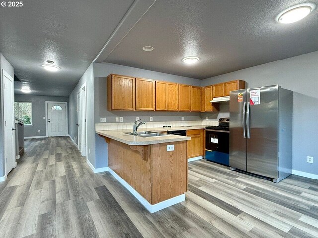 301 SE 129th Ave, Portland, OR 97233 - kitchen featuring electric range, freestanding refrigerator, a sink, a textured ceiling, and under cabinet range hood