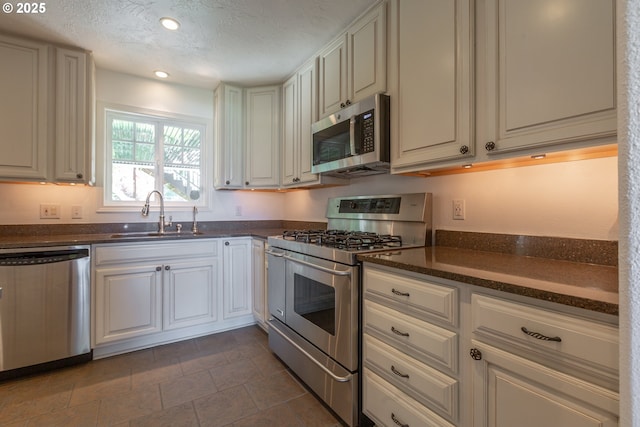 7105 Mississippi Dr, Vancouver, WA 98664 - kitchen featuring appliances with stainless steel finishes, a sink, a textured ceiling, stone finish flooring, and recessed lighting