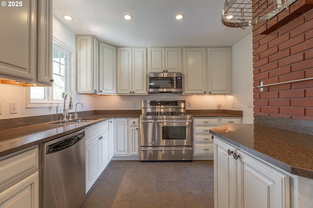 7105 Mississippi Dr, Vancouver, WA 98664 - kitchen with appliances with stainless steel finishes, a sink, recessed lighting, dark tile patterned flooring, and white cabinets