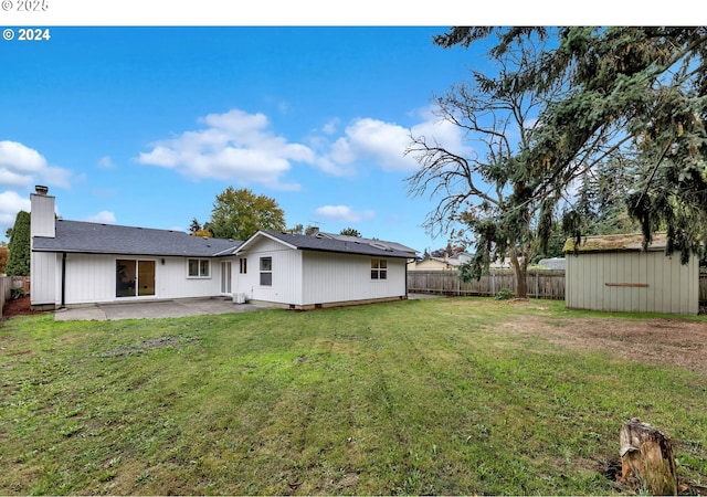 back of property with a patio area and a lawn