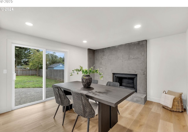 dining space featuring a fireplace and light wood-type flooring