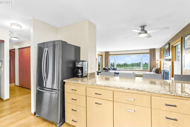 2801 Willows Rd Unit 1, Seaview, WA 98644 - kitchen with light brown cabinets, freestanding refrigerator, light stone countertops, light wood-type flooring, and a ceiling fan