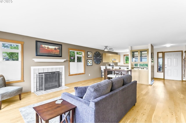 2801 Willows Rd Unit 1, Seaview, WA 98644 - living room featuring a tiled fireplace, light wood finished floors, and a ceiling fan