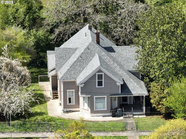 644 4th St, Myrtle Point, OR 97458 - back of house featuring roof with shingles, a fenced front yard, and a patio area