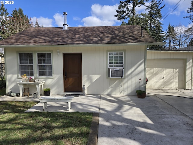 view of front of home featuring a garage, cooling unit, and roof with shingles