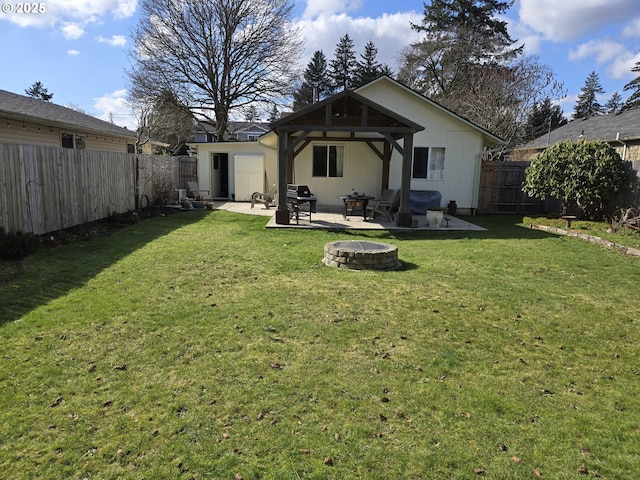 back of property featuring an outdoor fire pit, a fenced backyard, a yard, and a gazebo