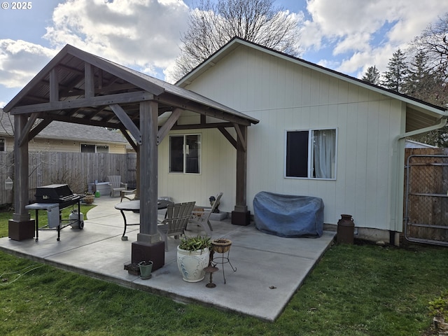 rear view of house featuring fence, a gazebo, and a patio