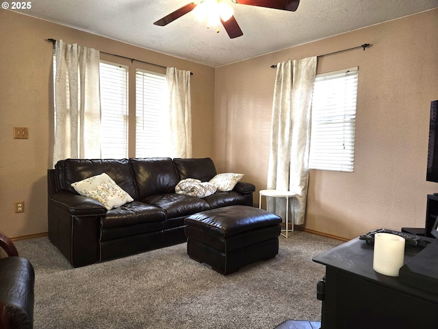 carpeted living area with ceiling fan, a textured ceiling, and baseboards