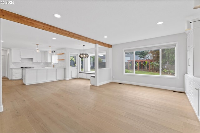19338 Inishbride Ct, Oregon City, OR 97045 - unfurnished living room with beamed ceiling, recessed lighting, a chandelier, and light wood-type flooring