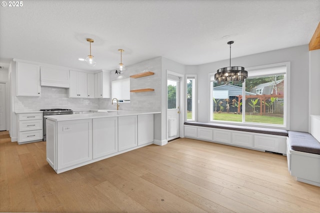 19338 Inishbride Ct, Oregon City, OR 97045 - kitchen with stainless steel range with gas cooktop, light wood-style floors, white cabinetry, and healthy amount of natural light