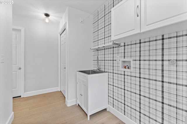 19338 Inishbride Ct, Oregon City, OR 97045 - washroom with washer hookup, light wood-type flooring, and cabinet space
