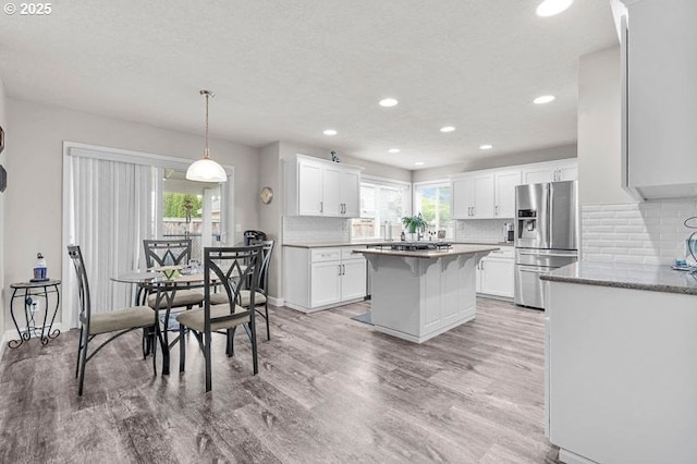 715 Shadowwood Loop, Keizer, OR 97303 - kitchen featuring stainless steel refrigerator with ice dispenser, light wood-style floors, a kitchen island, recessed lighting, and white cabinetry