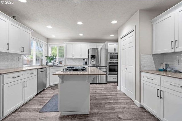 715 Shadowwood Loop, Keizer, OR 97303 - kitchen featuring appliances with stainless steel finishes, decorative backsplash, a textured ceiling, white cabinetry, and recessed lighting