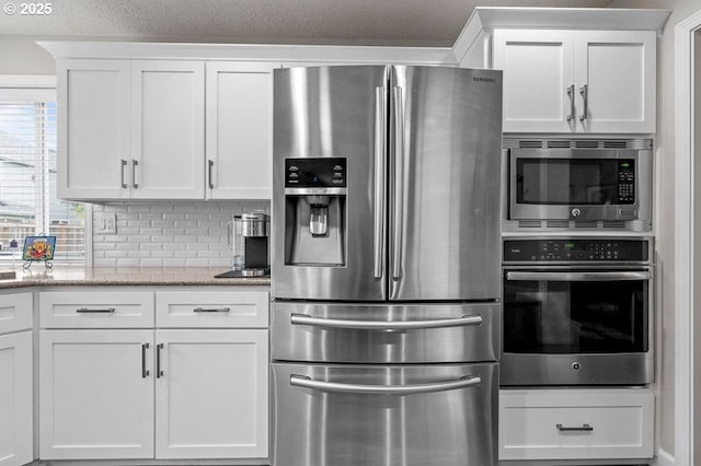 715 Shadowwood Loop, Keizer, OR 97303 - kitchen with appliances with stainless steel finishes, white cabinets, light stone counters, and backsplash