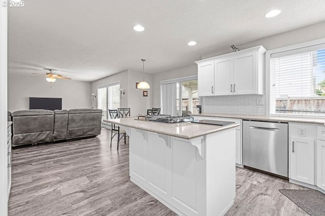 715 Shadowwood Loop, Keizer, OR 97303 - kitchen featuring dishwasher, a kitchen breakfast bar, light wood-type flooring, white cabinetry, and recessed lighting
