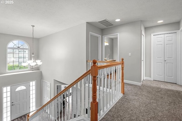 715 Shadowwood Loop, Keizer, OR 97303 - hallway featuring an upstairs landing, a chandelier, a textured ceiling, carpet floors, and recessed lighting