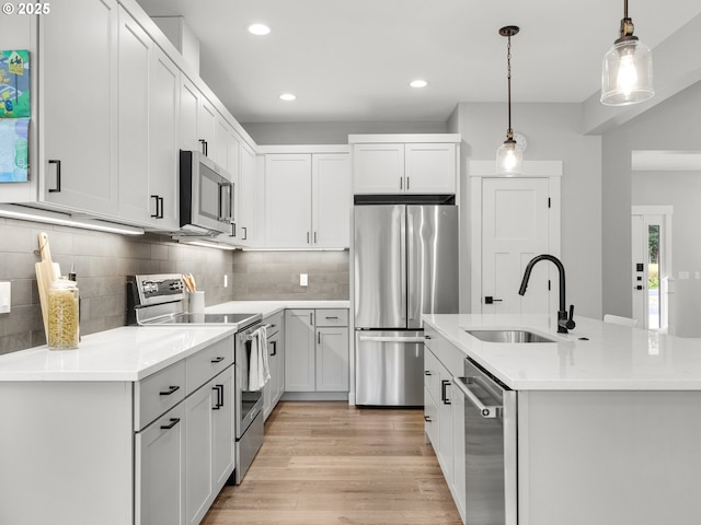 37330 Labiske Ln, Astoria, OR 97103 - kitchen featuring stainless steel appliances, a sink, light wood-style flooring, recessed lighting, and light countertops