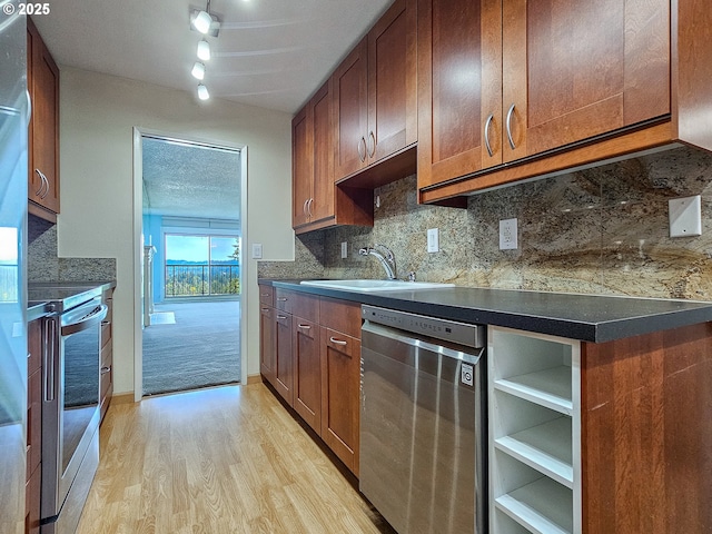 213 Oswego, Lake Oswego, OR 97035 - kitchen featuring stainless steel appliances, light wood finished floors, backsplash, dark countertops, and rail lighting