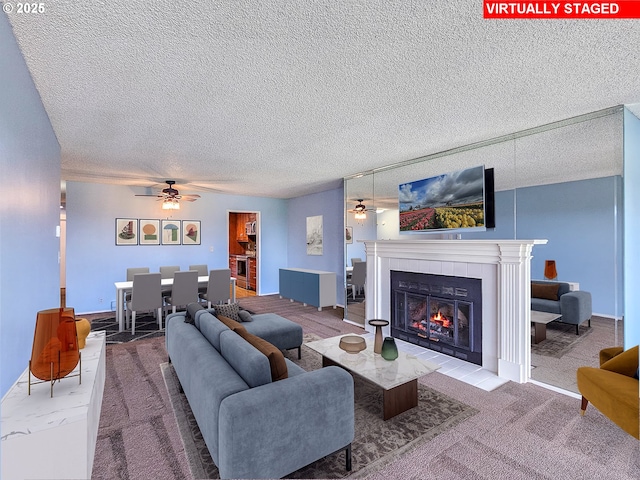 213 Oswego, Lake Oswego, OR 97035 - living area featuring ceiling fan, a tiled fireplace, a textured ceiling, and carpet floors