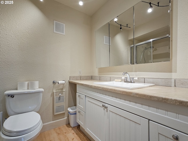 213 Oswego, Lake Oswego, OR 97035 - bathroom featuring vanity, wood finished floors, an enclosed shower, and a textured wall