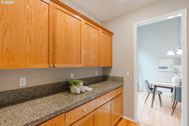 555 NE 58th Ave, Hillsboro, OR 97124 - kitchen with light wood-type flooring, baseboards, a chandelier, and stone countertops
