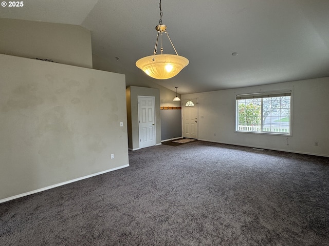 empty room with dark carpet, baseboards, and vaulted ceiling