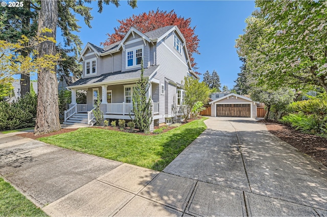 traditional-style home featuring covered porch, an outdoor structure, a front yard, and a garage