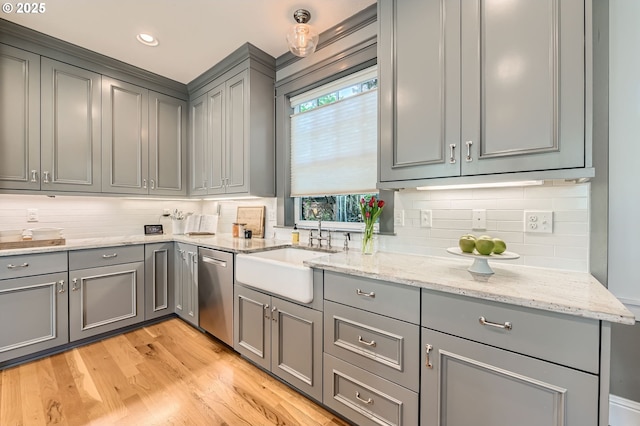 kitchen with backsplash, light wood-type flooring, dishwasher, gray cabinetry, and a sink