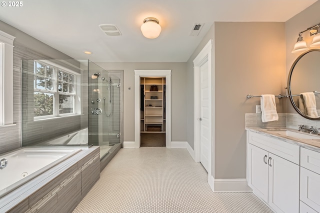 bathroom with visible vents, vanity, a tub with jets, a shower stall, and a spacious closet