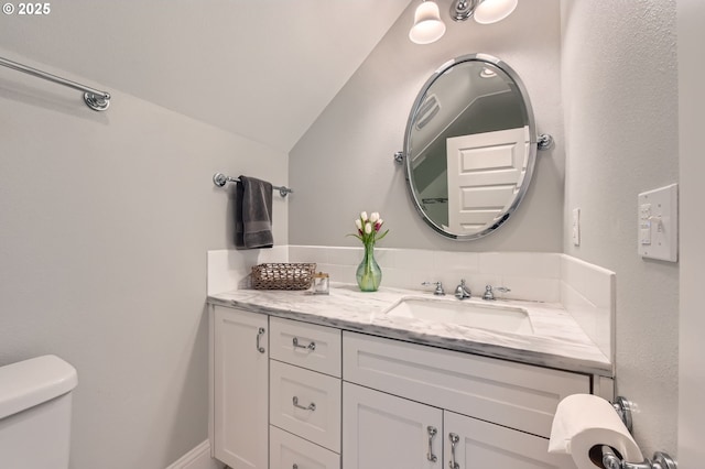 bathroom with vanity, vaulted ceiling, and toilet