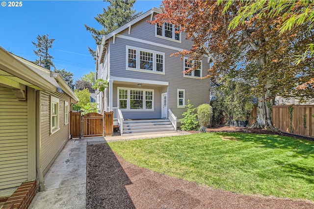 back of house with a yard, fence, and a gate