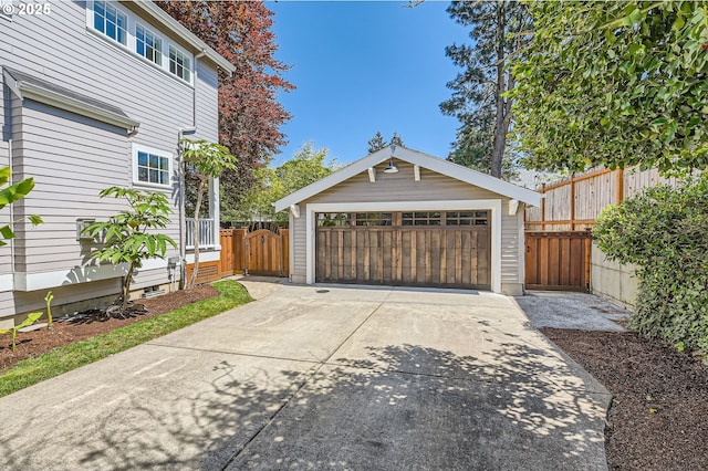 detached garage with a gate and fence