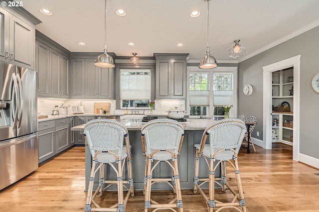 kitchen featuring stainless steel fridge, gray cabinets, light stone countertops, and tasteful backsplash